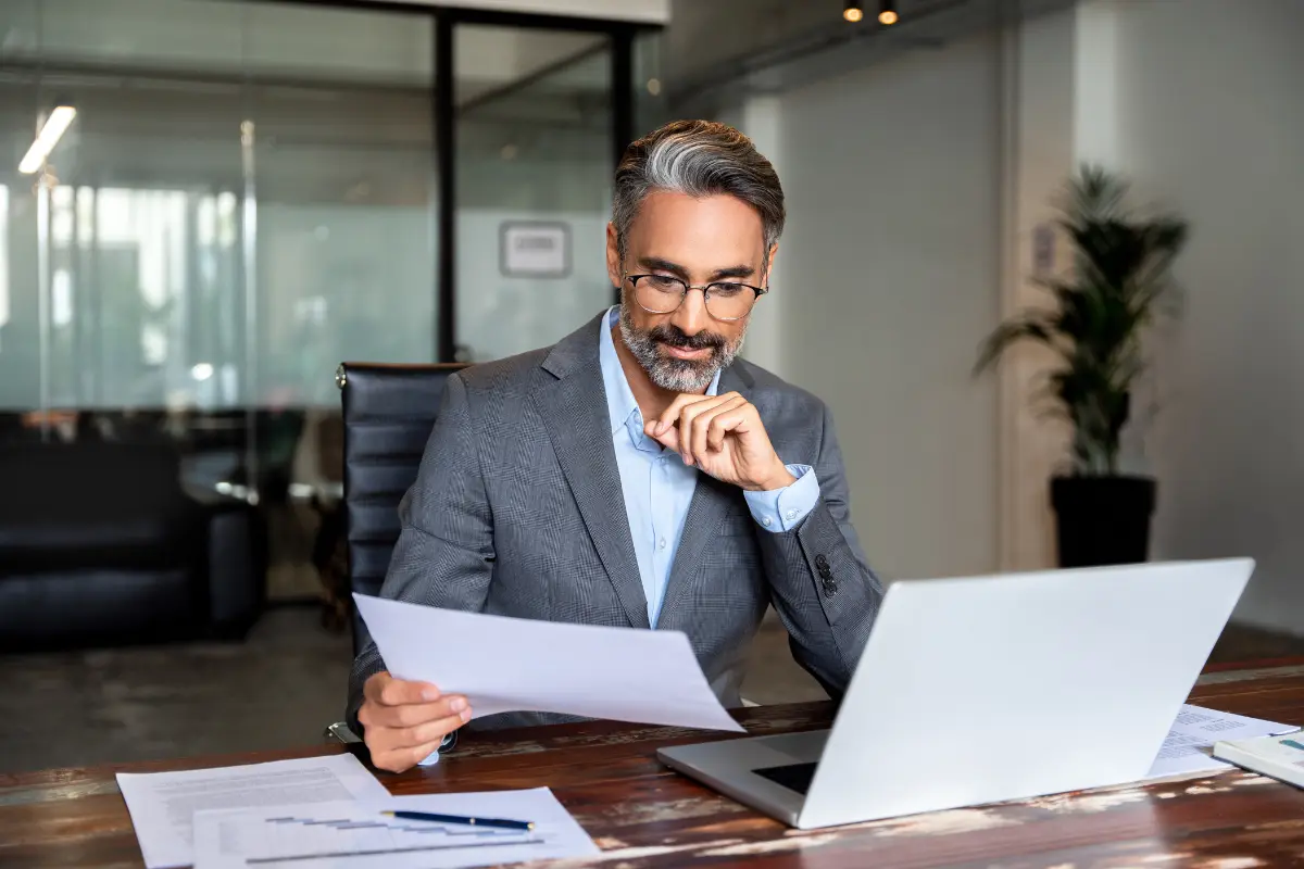 LLC owner reviewing business succession planning documents including buy-sell agreement and LLC operating agreement succession clause to protect business assets and ensure family business continuity