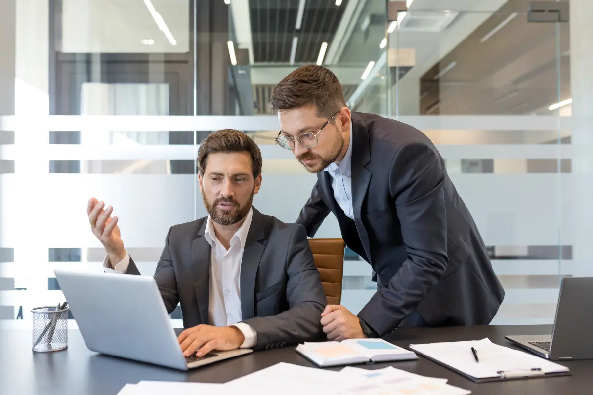 Business professionals reviewing commercial registered agent services and multi-state registered agent compliance requirements on a laptop.