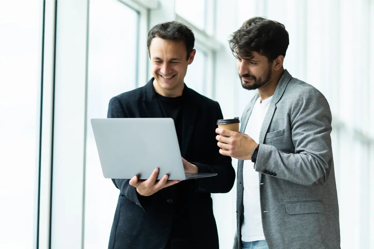 Business partners reviewing LLC formation timeline and state filing times on a laptop to understand how long it takes to start a business and plan their LLC registration process