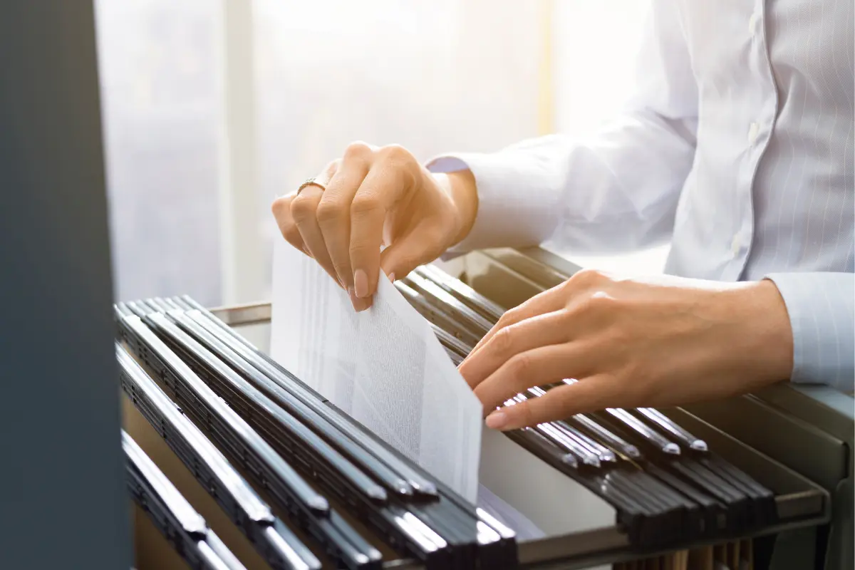 Business owner organizing and retaining business records following record keeping requirements for closed businesses and IRS record retention guidelines.