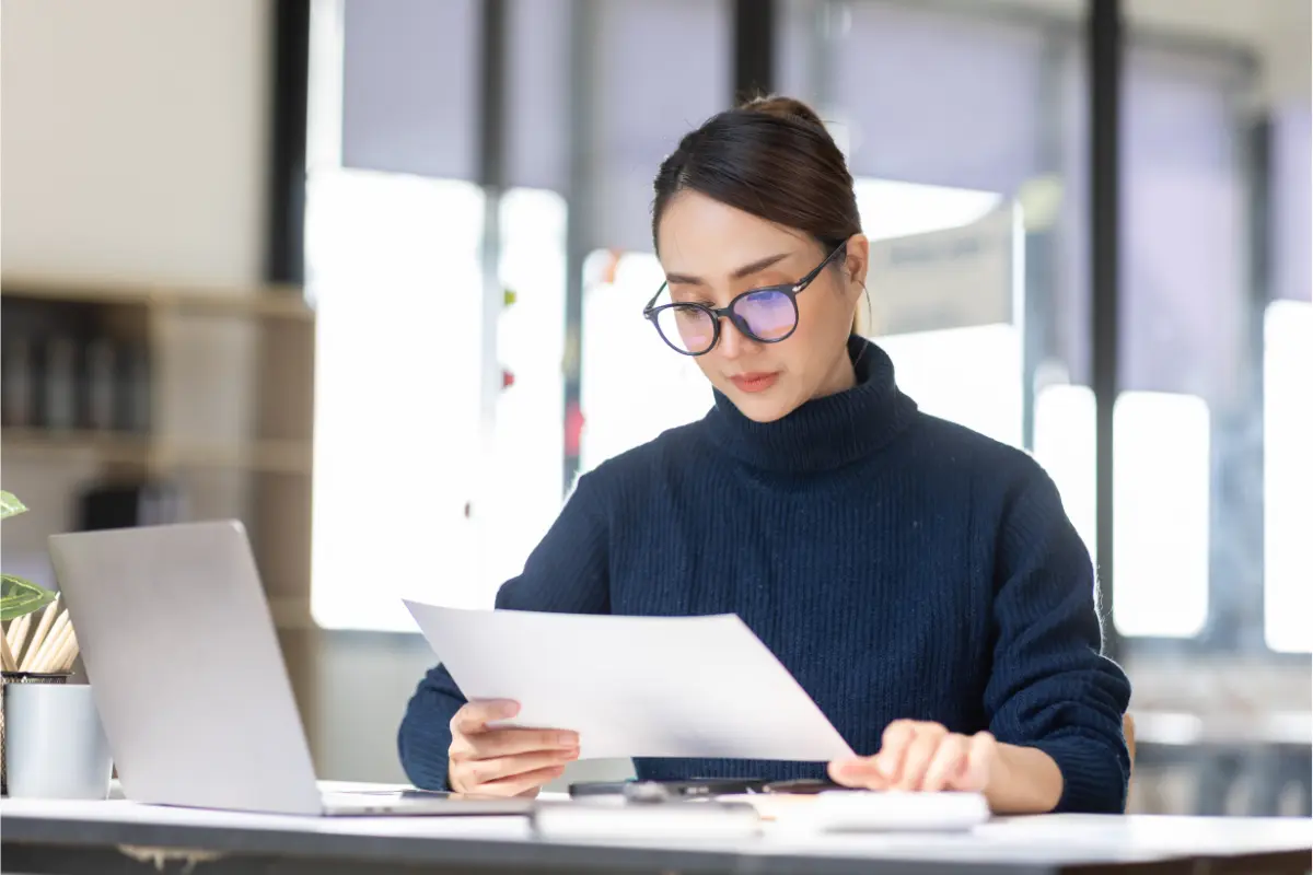 Professional reviewing annual report filing requirements and business compliance documents at office desk