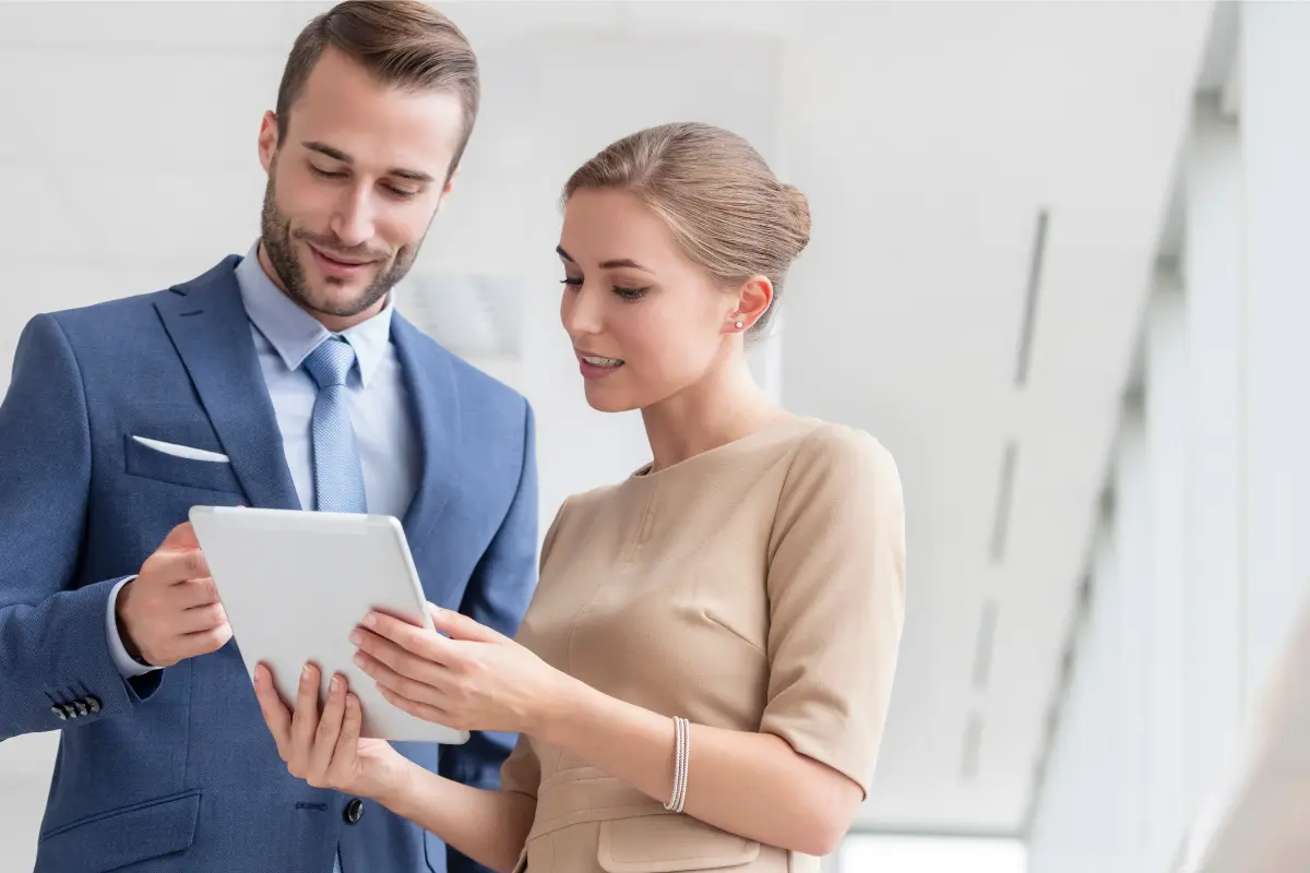 Two LLC partners reviewing a multi-member operating agreement and profit sharing terms on tablet before signing