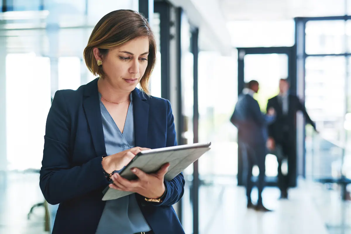 Real estate investor reviewing rental property LLC formation options and pros and cons of putting rental property in an LLC versus personal name on tablet