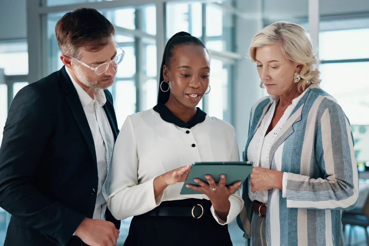 Small business owner scaling LLC from solo to team by onboarding first employee at office computer workstation